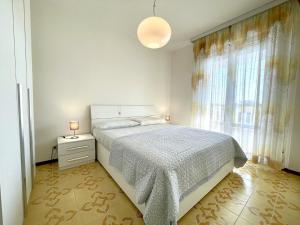 een witte slaapkamer met een bed en een raam bij Property in Porto Santa Margherita VE in Porto Santa Margherita di Caorle