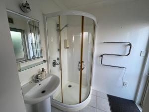 a bathroom with a shower and a sink at Beachside Bliss in Tauranga