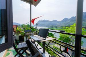 laptopa siedzącego na stole na balkonie w obiekcie Son River Homestay w mieście Phong Nha