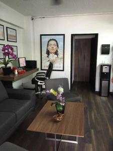 ein Wohnzimmer mit einem Sofa und einem Tisch mit Blumen in der Unterkunft Aurora Suites in Guadalajara