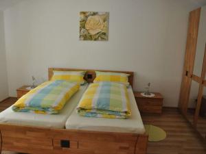 1 dormitorio con cama de madera y almohadas amarillas y azules en Antonia Comfortable holiday residence, en Witzenhausen