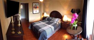 a bedroom with a bed and a table with flowers at Aurora Suites in Guadalajara
