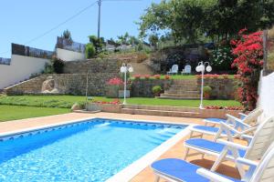 a swimming pool with two chairs and a yard at Apartamentos Maritimo Suites-Solo Adultos in O Grove