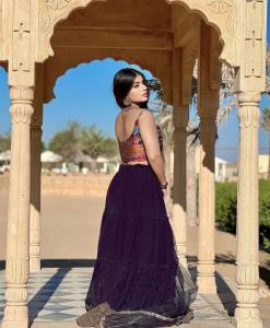 Una mujer con un vestido púrpura parada en un edificio en Desert Heritage Luxury Camp And Resort, en Jaisalmer
