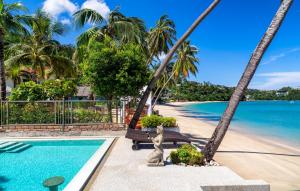 un complejo con piscina y palmeras en Mango Tree Villa, en Panwa Beach