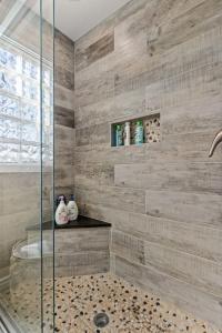 a bathroom with a shower with a glass at Villa Bella elegant family retreat in downtown in Bentonville