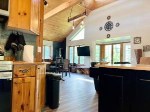 a kitchen with a counter and a dining room at Lovely Muskoka Waterfront Cottage-Hot tub & Sauna! in Bracebridge