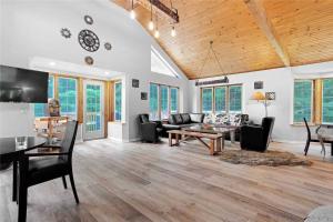 a living room with a couch and a table at Lovely Muskoka Waterfront Cottage-Hot tub & Sauna! in Bracebridge