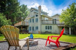 two chairs sitting in front of a house at Lovely Muskoka Waterfront Cottage-Hot tub & Sauna! in Bracebridge