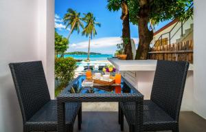 a table and two chairs on a balcony with a view of the ocean at Mango Tree Villa in Panwa Beach