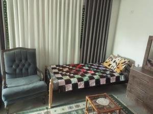 a bedroom with a bed and a chair at Studio Apartment fully furnished super deloux 