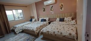 開羅的住宿－Moon Homes，一间卧室设有两张床和窗户。