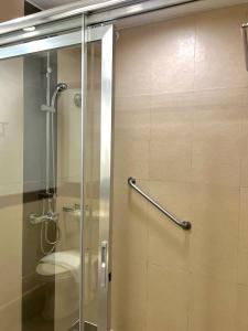 W łazience znajduje się przeszklony prysznic i toaleta. w obiekcie The Forest Lodge at Camp John Hay with balcony and parking privately owned unit 272 w mieście Baguio