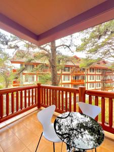 The Forest Lodge at Camp John Hay with balcony and parking privately owned unit 272 في باغيو: بلكونه مع طاوله وكراسي وشجر