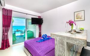 a bedroom with a purple bed and a view of the ocean at Mango Tree Villa in Panwa Beach