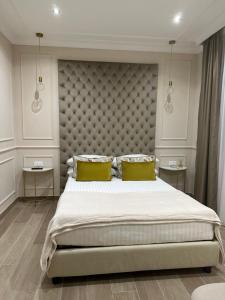 a bedroom with a large bed with two yellow pillows at NLM Boutique Suites in Rome