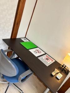 een zwart bureau met een blauwe stoel en een schoolbord bij TSUBAME 202 staying private home in Osaka