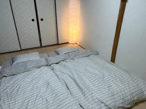 een groot wit bed in een kamer bij TSUBAME 202 staying private home in Osaka