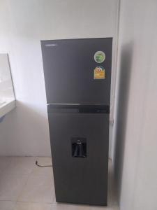 a black refrigerator sitting next to a wall at Koh Tao Townhouse in Koh Tao