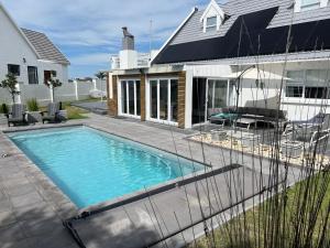 una piscina davanti a una casa di THE SURF AND GOLF HUIS Solar Power a St Francis Bay