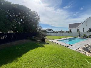 un cortile con piscina e una casa di THE SURF AND GOLF HUIS Solar Power a St Francis Bay Altre 54 foto