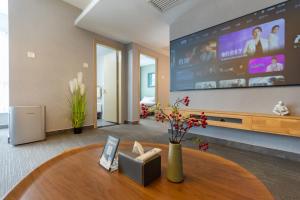 a living room with a table and a large screen at Yise Serviced Apartment -Beijing CCTV Shop in Beijing