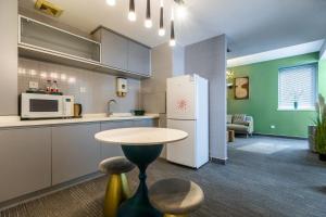 a kitchen with a table and a refrigerator at Yise Serviced Apartment -Beijing CCTV Shop in Beijing