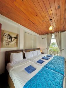 ein Schlafzimmer mit einem großen Bett mit blauer Bettwäsche in der Unterkunft Royal Pearl Hills in Nuwara Eliya
