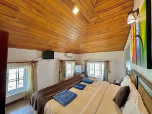 - une chambre avec un grand lit et un plafond en bois dans l'établissement Royal Pearl Hills, à Nuwara Eliya