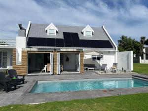 una casa con pannelli solari sul tetto di THE SURF AND GOLF HUIS Solar Power a St Francis Bay