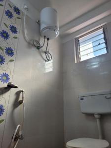 La salle de bains blanche est pourvue de toilettes et d'une fenêtre. dans l'établissement Mysa Homestay, à Rānchī