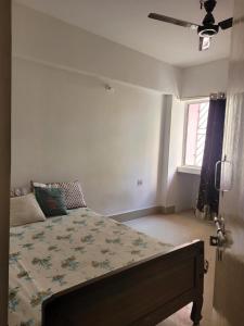 1 dormitorio con 1 cama y ventilador de techo en Mysa Homestay en Ranchi
