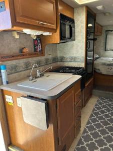 uma cozinha com um lavatório e um fogão num trailer em Road to Happiness em Fort Worth