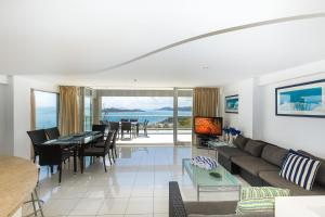 a living room with a couch and a table at Ocean Sunsets - Skiathos in Hamilton Island