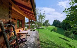 un portico di una casa in legno con tavolo e sedie di Das Alm-Chalet-Chiemsee a Bernau am Chiemsee