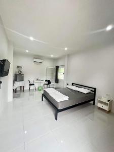 a bedroom with a bed and a table and a tv at แหลมงอบเฮาส์ laemngob House in Laem Ngop