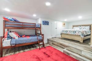 a bedroom with two bunk beds and a red rug at Arcade Palace on the Lake in Garfield