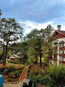 ein Haus mit einer orangenen Treppe neben einem Gebäude in der Unterkunft Forest Lodge at Camp John Hay privately owned - Deluxe Queen Suite with balcony and Parking 269 in Baguio City