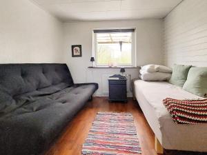 ein Wohnzimmer mit einem Sofa und einem Fenster in der Unterkunft Holiday home Skjern XXI in Skjern
