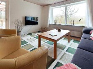 ein Wohnzimmer mit einem Tisch und einem Sofa in der Unterkunft Holiday home Skjern XXI in Skjern