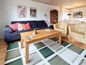 ein Wohnzimmer mit einem blauen Sofa und einem Tisch in der Unterkunft Holiday home Skjern XXI in Skjern