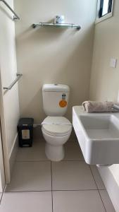 a white bathroom with a toilet and a sink at Three Moon Motel in Monto