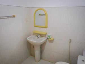 a white bathroom with a sink and a mirror at The White House in Trincomalee