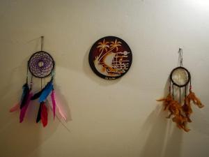 a wall with three dream clocks and feathers on it at The White House in Trincomalee