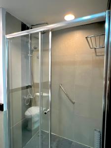 a bathroom with a glass shower with a toilet at The Forest Lodge at Camp John Hay privately owned unit with parking 371 in Baguio