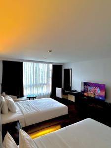 a hotel room with two beds and a flat screen tv at The Forest Lodge at Camp John Hay privately owned unit with parking 371 in Baguio