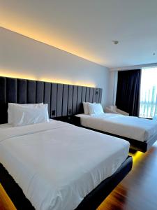 2 camas en una habitación de hotel con 2 colchas en The Forest Lodge at Camp John Hay privately owned unit with parking 371, en Baguio