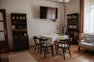 a dining room with a table and chairs and a couch at Dobay Apartman Gyula in Gyula