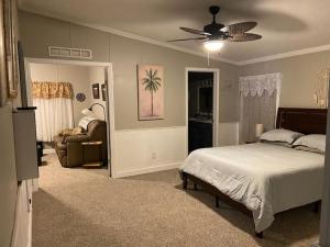 1 dormitorio con 1 cama y ventilador de techo en Florida Woodland Retreat, en Masaryktown