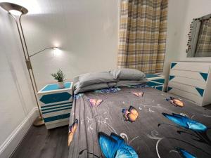 a bedroom with a bed with butterflies on it at **Dream Home** Near Seaside (Southend on Sea) in Southend-on-Sea